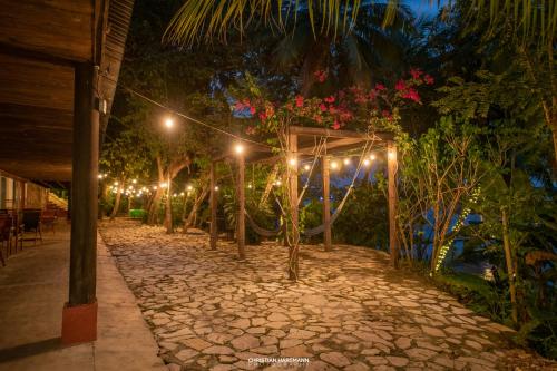 a pathway lit up at night with lights at Hotel Gringo Perdido in El Remate