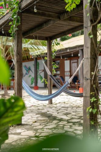a hammock hanging from a porch of a house at Hotel Gringo Perdido in El Remate