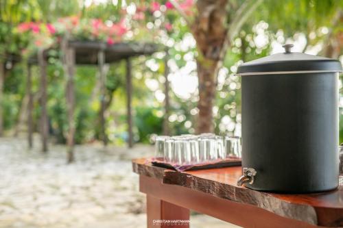 a black trash can sitting on a wooden table at Hotel Gringo Perdido in El Remate