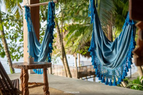a couple of blue hammocks hanging from a porch at Hotel Gringo Perdido in El Remate