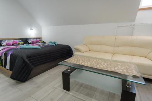 a living room with a bed and a couch at Villa Zarra in Habovka