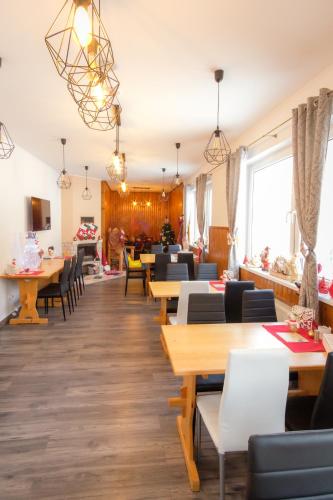 a restaurant with tables and chairs in a room at Villa Zarra in Habovka