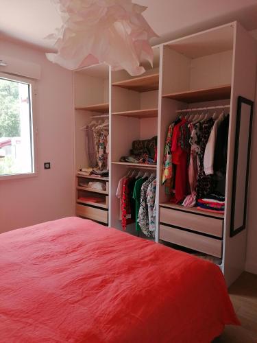 - une chambre avec un lit rouge et un placard dans l'établissement Superbe appartement face au lac d'Hossegor, à Soorts-Hossegor