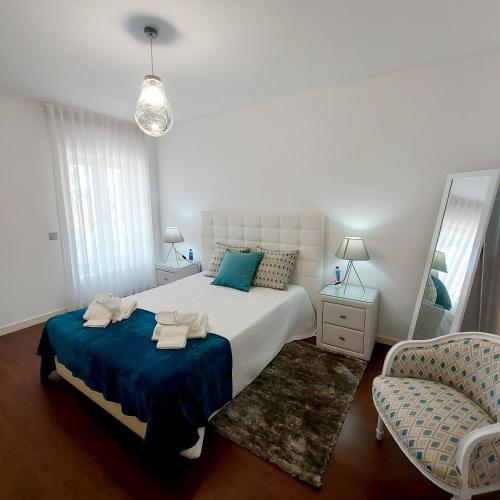 a bedroom with a bed and a chair and a mirror at Casa De Luxo em Esposende in Esposende