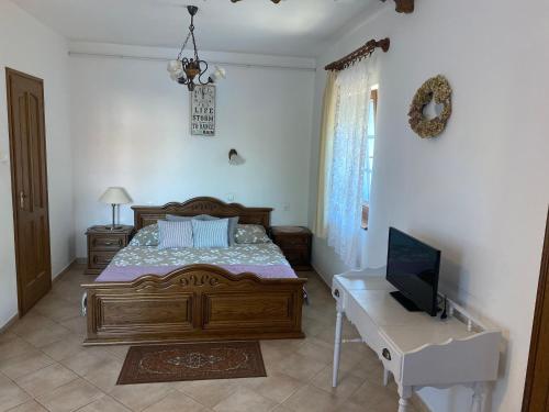 a bedroom with a bed and a desk with a television at Levendula Apartman Zalakaros in Zalakaros