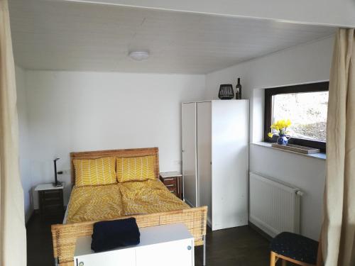 a bedroom with a bed and a white refrigerator at Your Suite Runkel - Runkel, you're sweet! in Runkel
