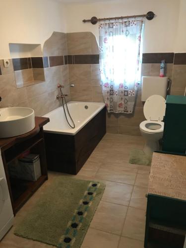 Un baño con bañera, inodoro y lavabo. en Siposréti Apartmanház, en Szentgyörgyvár
