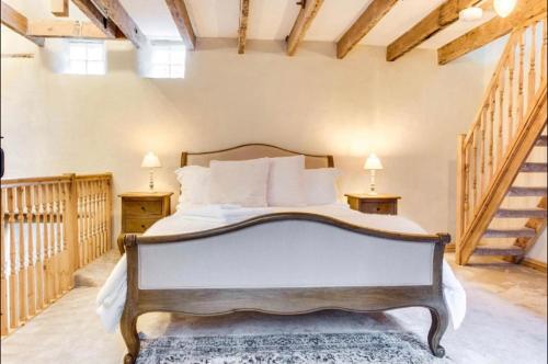 a bedroom with a bed with two tables and two stairs at The Cow House - In the heart of Whitby in Whitby