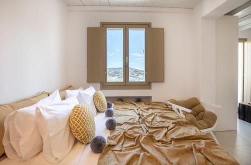 a bedroom with a large bed with pillows at Due Mari Mykonos in Agios Ioannis Mykonos