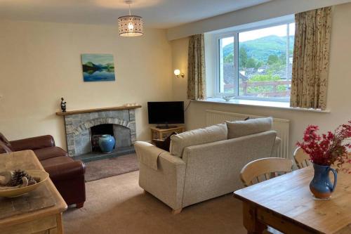 a living room with a couch and a fireplace at Lane Foot Family accommodation Winter Deals Nov to March on 3 nts or more in Ambleside
