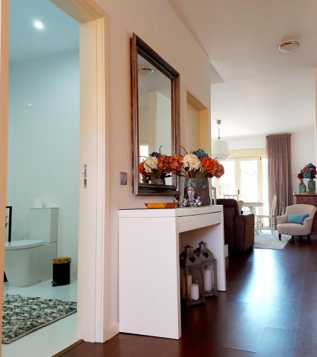 a living room with a mirror and a vase of flowers at Casa De Luxo em Esposende in Esposende