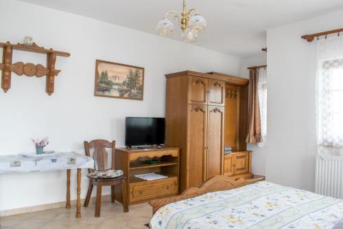a bedroom with a bed and a cabinet and a television at Levendula Apartman Zalakaros in Zalakaros