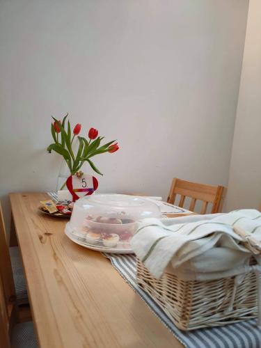 a table with a basket and a vase with flowers on it at Hołdysówka przy Gondoli in Szczyrk
