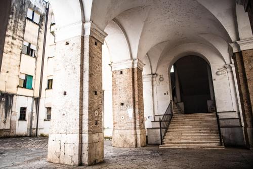 un edificio antiguo con escaleras y un arco en B&B Boteroom en Cassino