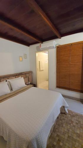 a bedroom with a white bed and a window at Garimpo da Terra Suítes in Mucugê