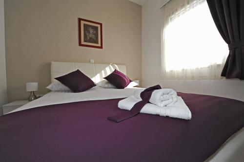 a bedroom with a large bed with towels on it at Apartments Villa Violet in Zadar