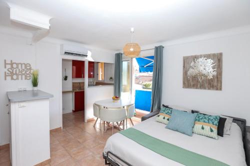 1 dormitorio con 1 cama y cocina con mesa en Le Provençale : Plages, Balcon, Clim, en Vallauris