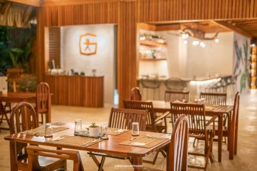 a dining room with wooden tables and chairs at Hotel Gringo Perdido in El Remate