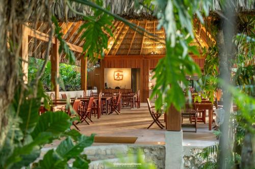a restaurant with tables and chairs in a building at Hotel Gringo Perdido in El Remate