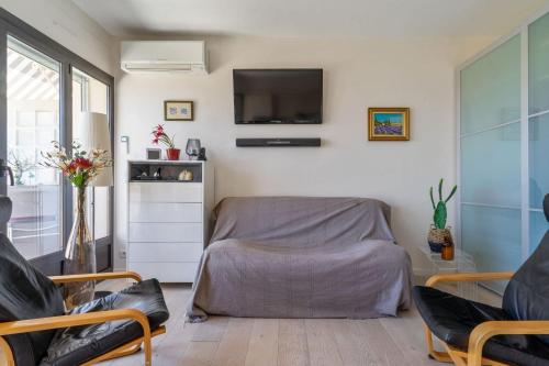 Cette chambre comprend un lit et une télévision murale. dans l'établissement Appartement Ganteaume - Welkeys, à Cassis