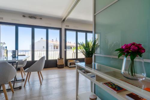 uma sala de estar com uma mesa e um vaso de flores em Superb bright flat with balcony and sea view in Cassis - Welkeys em Cassis