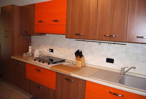 a kitchen with wooden cabinets and a sink at Taormina Suite Bardolino in Bardolino