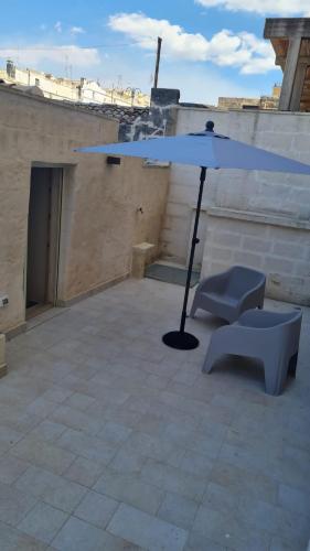 a blue umbrella sitting on top of a roof at LITHOS ROOMs in Matera