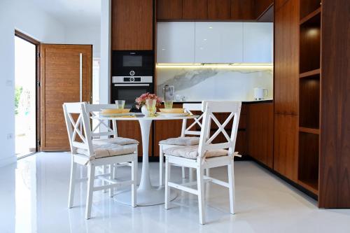 a kitchen with a white table and chairs at NEW!!! 2024 MAREA apartments with XXL Sunny Terrace in Poreč