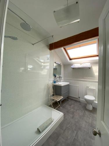 baño con bañera, aseo y ventana en Glenholmekendal en Kendal