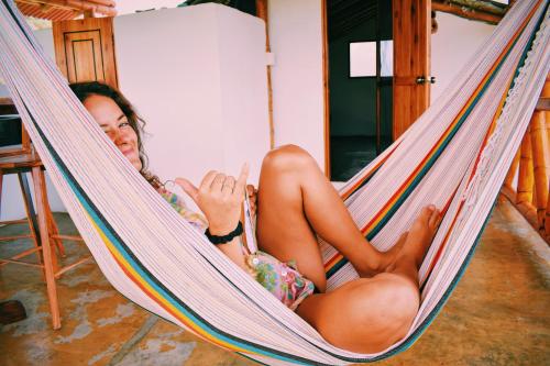 a woman is laying in a hammock at Hermanos Perdidos Surf in Las Tunas