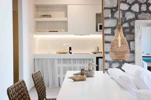 a dining room with a white table and chairs at Nirome Luxury Suites in Adamas