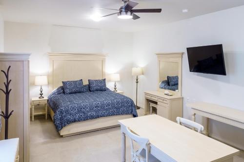 a bedroom with a bed and a tv and a table at La Casa de Pino in Oaxaca City