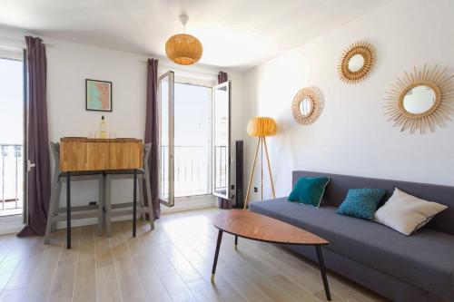 un salon avec un canapé et une table dans l'établissement Appartement Joliette - Welkeys, à Marseille