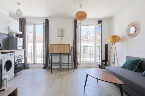 un salon avec un canapé et une table dans l'établissement Appartement Joliette - Welkeys, à Marseille