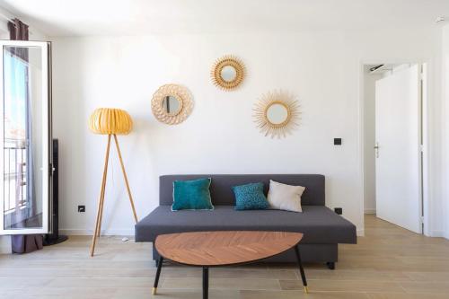 - un salon avec un canapé et des miroirs sur le mur dans l'établissement Appartement Joliette - Welkeys, à Marseille