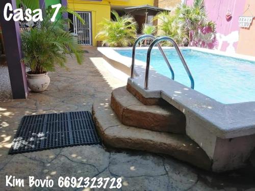 a pool with a bench next to a swimming pool at Casa 7 in Mazatlán