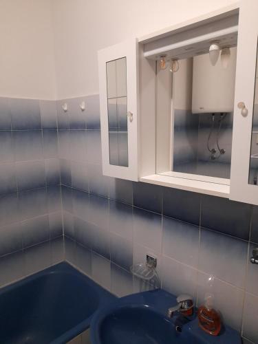 y baño con lavabo azul y espejo. en Apartment Mario, en Zadar