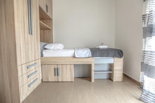 a small bedroom with a bed and a desk at Meteora's Secret Garden House#1 in Kalabaka