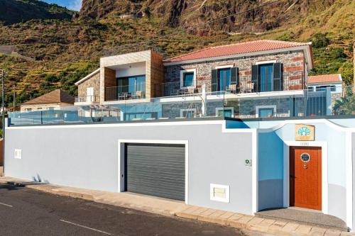 a house with a garage and a mountain at Villa Sea - Rural Holiday Experience by SeaPearl in Paul do Mar