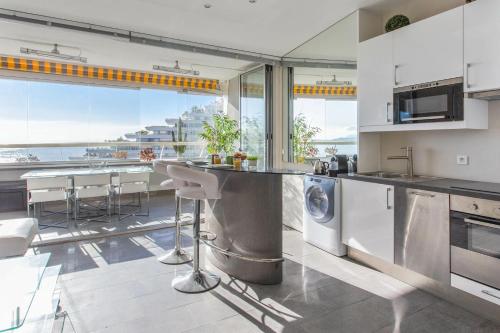 a kitchen with stainless steel appliances and a view of the ocean at Studio de la Baie des Anges - Welkeys in Villeneuve-Loubet