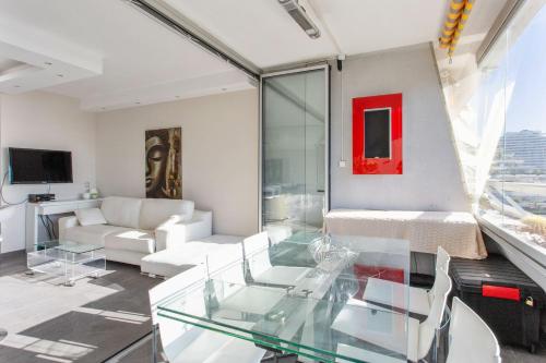 a living room with a glass table and a couch at Studio de la Baie des Anges - Welkeys in Villeneuve-Loubet