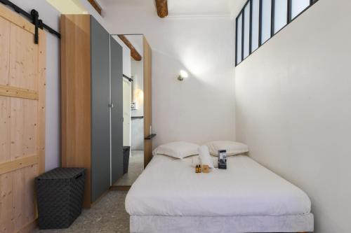 une petite chambre avec un lit dans une pièce dans l'établissement Studio Lugare - Welkeys, à Marseille