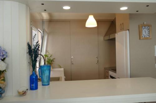 eine Küche mit einer weißen Arbeitsplatte und einem Kühlschrank in der Unterkunft Piso en Santa Cristina, a 150 m de la playa in Oleiros