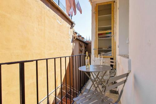 a balcony with a table with wine glasses on it at Beautiful flat with balcony in the heart of Marseille - Welkeys in Marseille