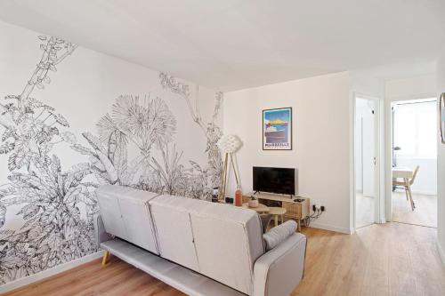 a living room with a couch and a tv on a wall at Beautiful flat with balcony in the heart of Marseille - Welkeys in Marseille