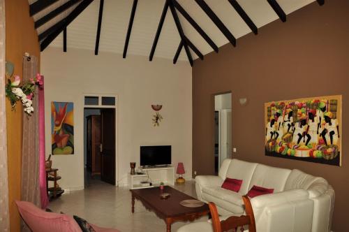 a living room with a white couch and a table at CHEZ Lise et RORO in Pointe-Noire