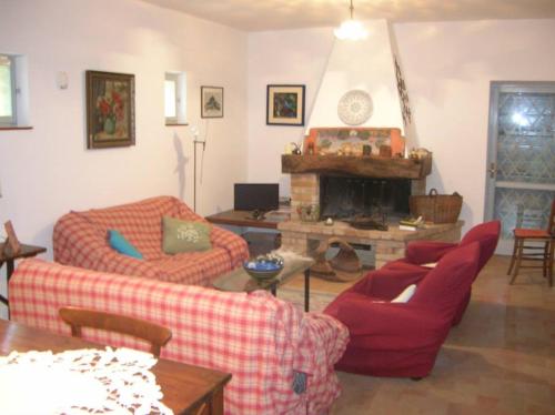 a living room with two couches and a fireplace at Country House "I luoghi dell' anima"con piscina e giardino in Montottone