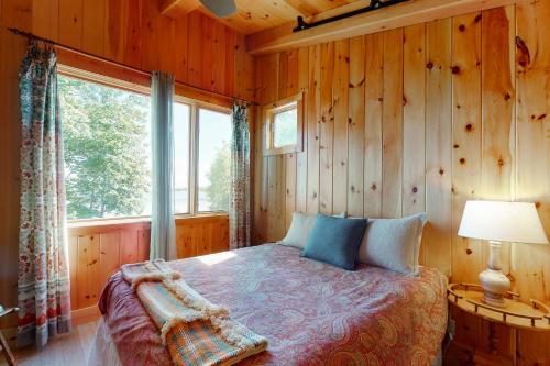 um quarto com uma cama e uma grande janela em Bayfront Beaut em North Hero