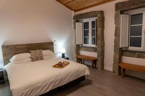 a bedroom with a large white bed and two windows at Penthouse Peaks - Casa Sao Joao -4 Star Tourist Apartments in Angra do Heroísmo