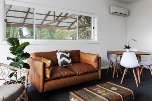 a living room with a couch and a table at Battery Point Manor in Hobart